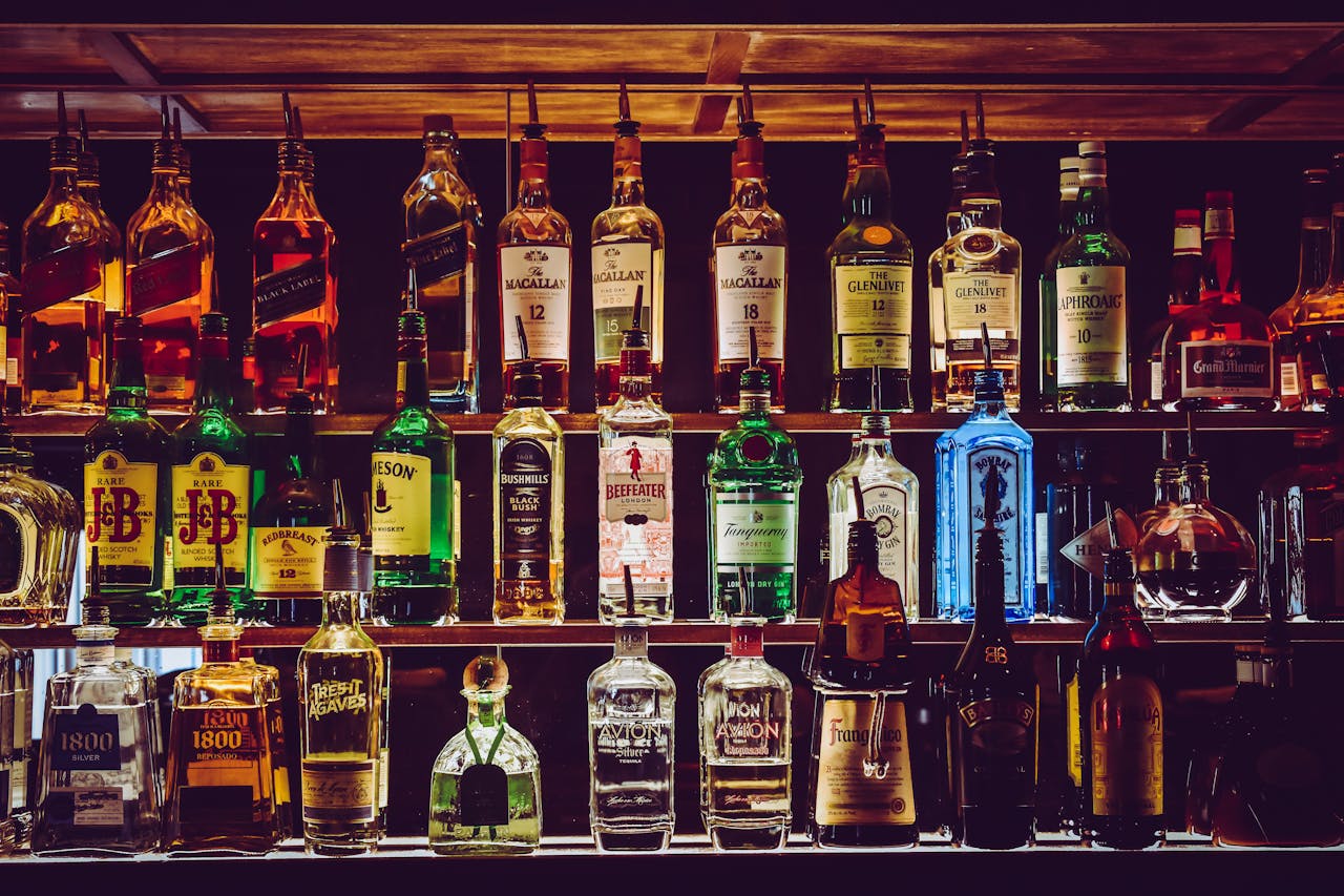 Services-02 An array of various liquor bottles beautifully displayed on a bar shelf.