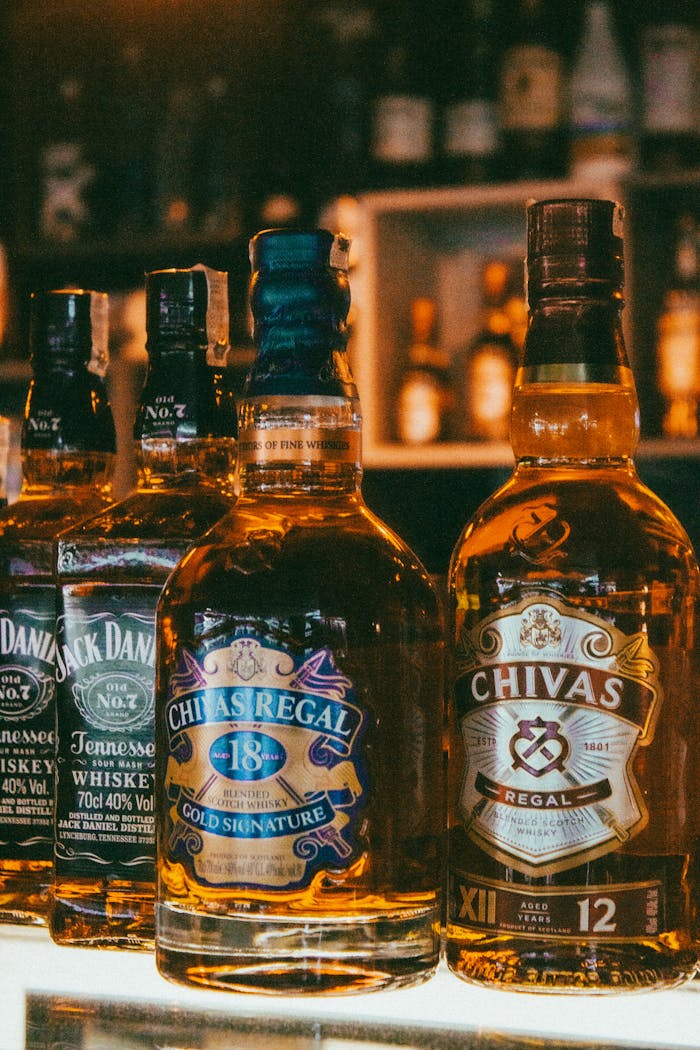 creative-02 Close-up of whisky bottles, including Chivas Regal, on a bar counter in Istanbul.