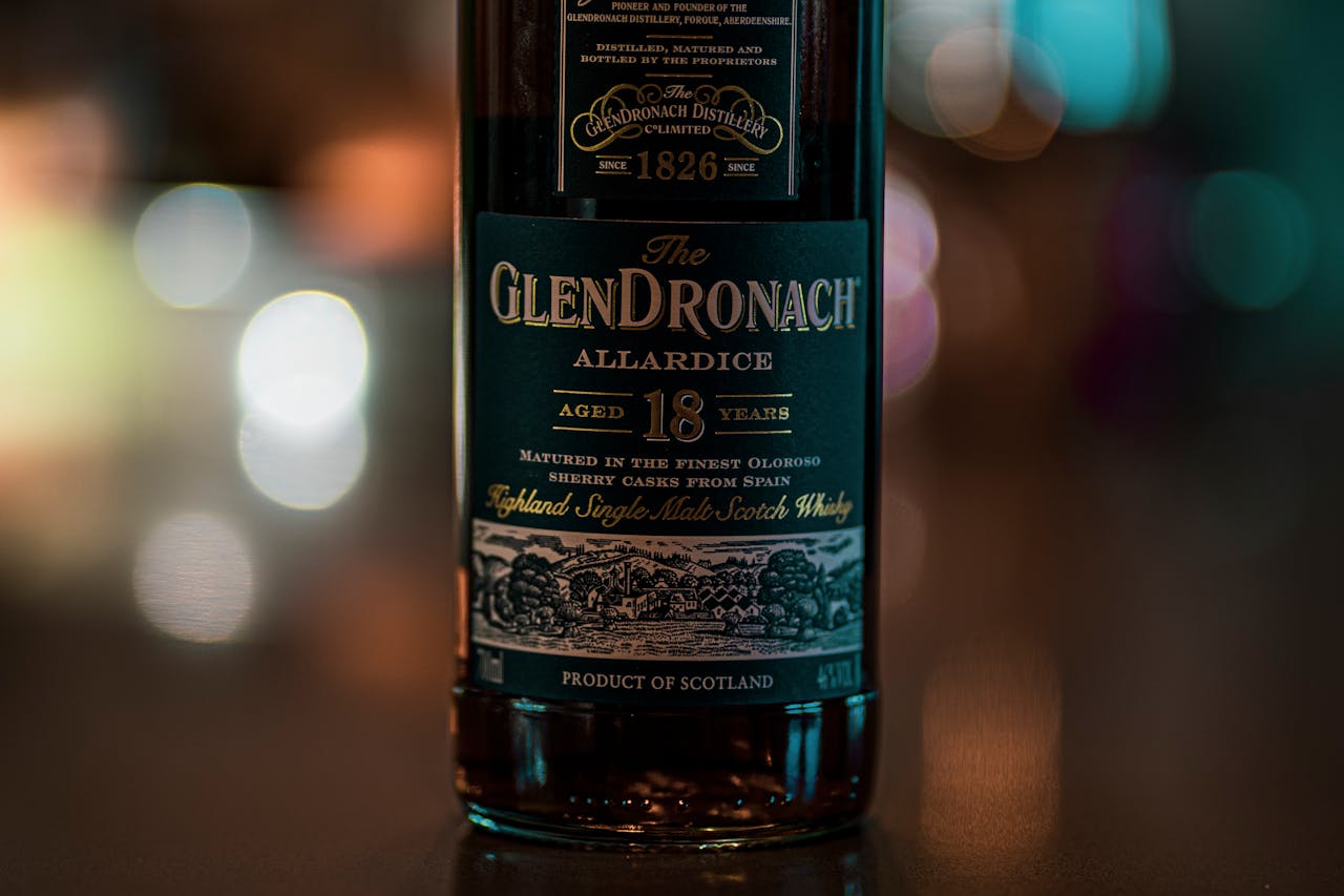 creative-03 Close-up of GlenDronach 18-Year-Old whisky bottle with bokeh lights.